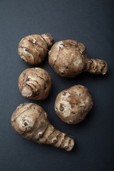 Tubers of Jerusalem artichoke on black background.