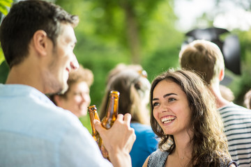 Group of young people celebrating outside. Focus on a  couple