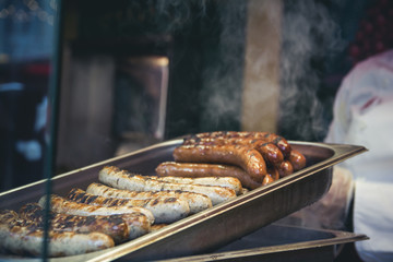 Grilling typical German sausages in a market stall - Oktoberfest - Christmas markets in Germany