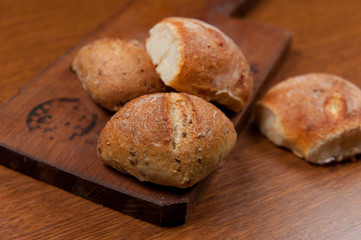fresh baked bread with cereals on cutting board on wooden table
