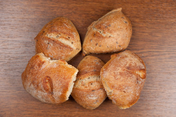 fresh baked bread with cereals on cutting board on wooden table