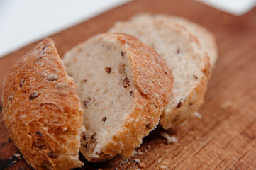 fresh baked bread with cereals on cutting board on wooden table
