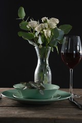 Setting a table for a dinner party with wine glass and flower