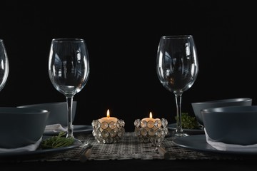 Elegance table setting with empty wine glasses and lit candle