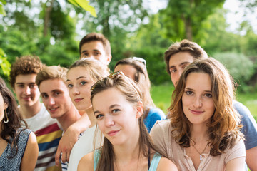 Group of  young people in a park, they are looking at camera