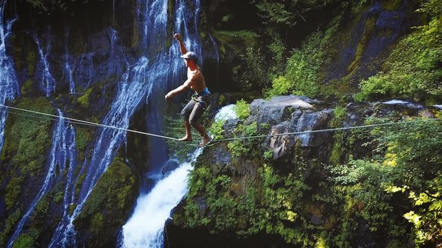 Fit Man Highlining Over A Waterfall In Oregon