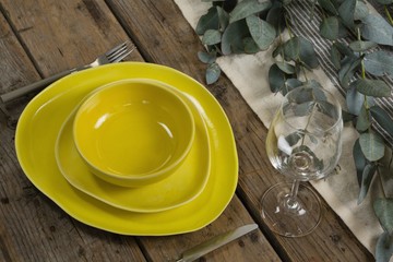 Stack of various dinnerware with cutlery and empty glass - Powered by Adobe