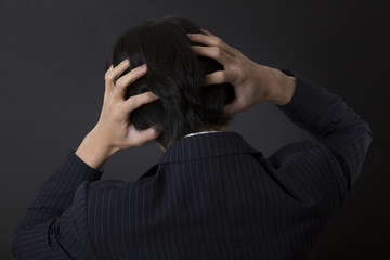 頭をかかえる男性
