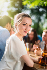 Group of young people having fun outside, focus on a young woman