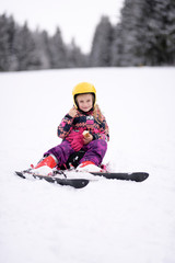 Fototapeta na wymiar Happy little girl skiing downhill