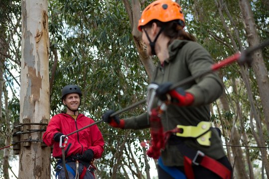 Hiker Couple Holding Zip Line Cable In The Forest