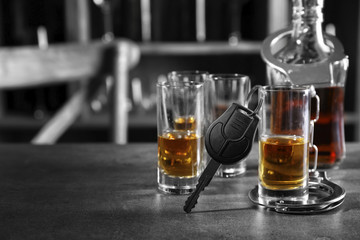 Composition with alcohol, handcuffs and car key in bar. Don't drink and drive concept