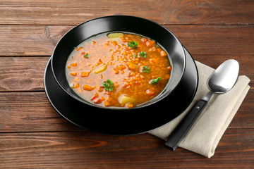 Plate with tasty lentil soup on table