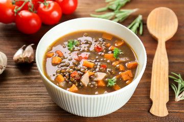 Dish with tasty lentil soup on table