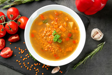 Dish with tasty lentil soup on table