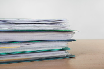 Stack of documents on table against light  background