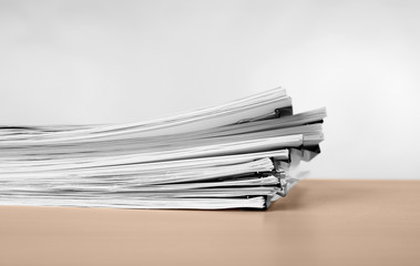 Stack of documents on table against light  background