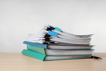 Stack of documents on table against light  background