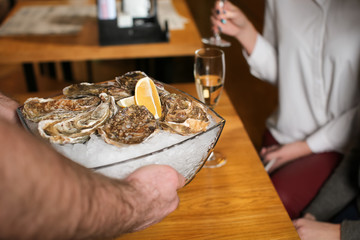Waiter serving oysters in restaurant