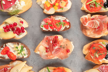 Delicious bruschettas on grey background, top view