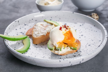 Tasty bruschetta with egg and avocado on plate, closeup