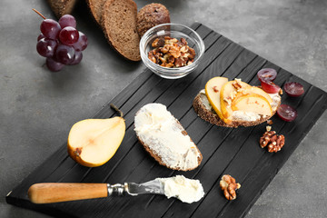 Wooden board with ingredients and delicious bruschetta on table