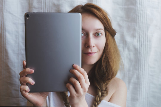 Beautiful ginger woman with metal tablet