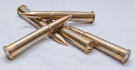 Several large caliber rifle bullets together on a white background
