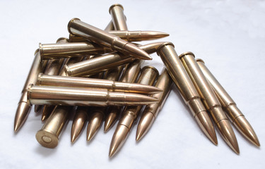 Several large caliber rifle bullets together on a white background