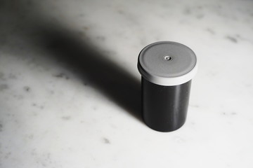 Isolated film canister on white marble