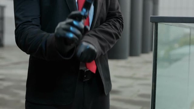 Hands in black gloves cock of a gun for a shot.