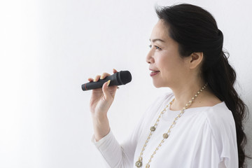 マイクを持って歌うミドル女性