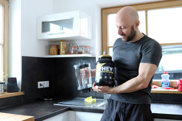 Sportler mit Protein in der Küche