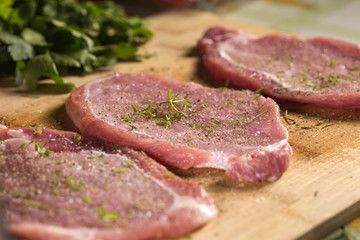 Pork chops on a cutting board with fresh herbs