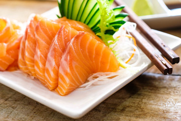 Sashimi, Salmon, Japanese food chopsticks and wasabi on the wood table
