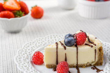Delicious cheesecake with strawberry and blueberry on a table top view.