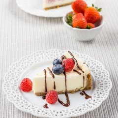 Delicious cheesecake with strawberry and blueberry on a table top view.