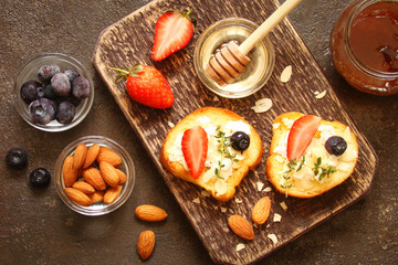 Toast with cream cheese, fresh strawberries, almond flakes, blueberries, honey and milk