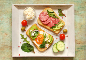 Toast with cream cheese, ricotta, herbs, sausage, avocado, egg, cucumber, tomato, spinach