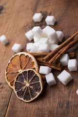 Dried orange with sugar and cinnamon on a wooden table
