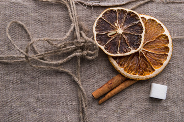 Dried orange with sugar and cinnamon on a wooden table