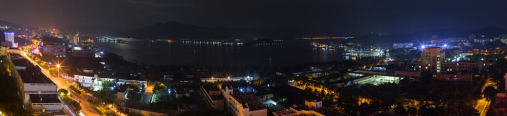 Fototapeta na wymiar Panoramic city landscape at night, view of Dadunhai Bay and the streets next to it in Sanya City on Hainan Island