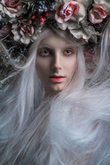 Woman with white hair and white roses and snow on face