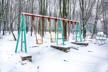 Empty swing in winter time with snow