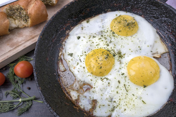 appetizing fried eggs in an old frying pan