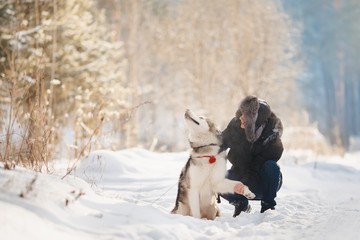 Training of dogs. Man is training her dog on street in winter. team give a paw.