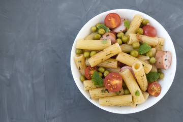 Appetizing pasta with vegetables, spices, sausages, green peas and sauce. Space for copy space.