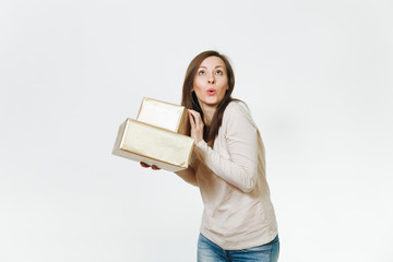 Pretty caucasian fun young happy woman in light clothes with shy charming smile, brown hair and two golden gift boxes with present, celebrating holiday on white background isolated for advertisement.