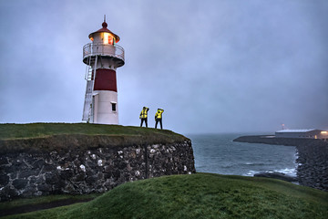 Fototapeta na wymiar Seashore with luminous lighthouse 