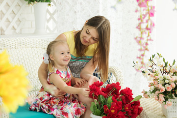 Young woman and little girl on the summer terrace